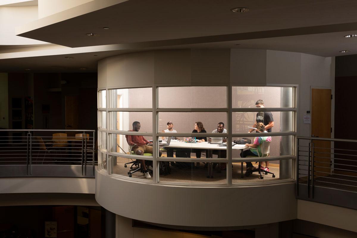 学生们在俯瞰戴维斯商学院的会议室里合作 & 技术的游说.