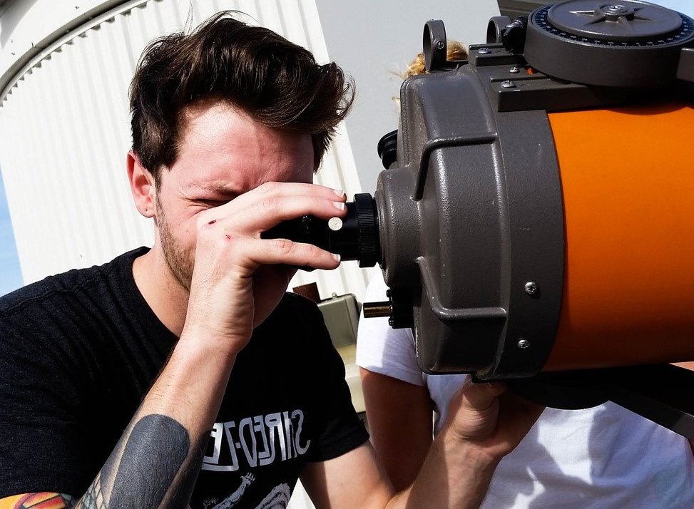 男生在用望远镜.